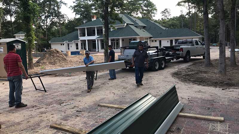 Unloading metal roof components prior to installation.