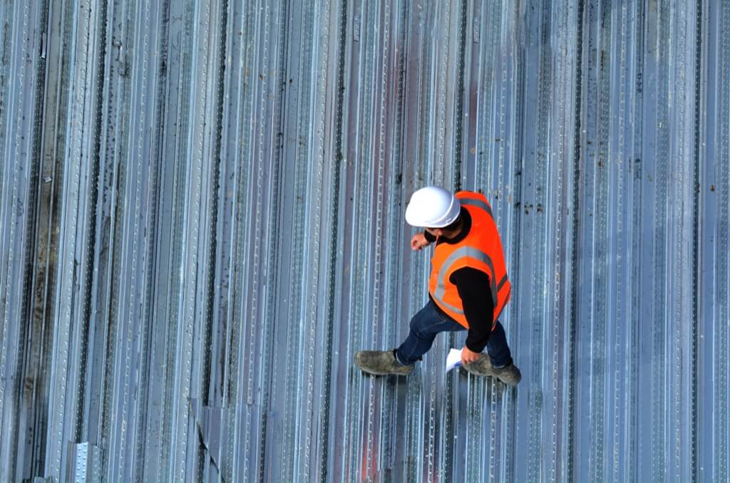 A commercial roofer in San Antonio is inspecting a roof.