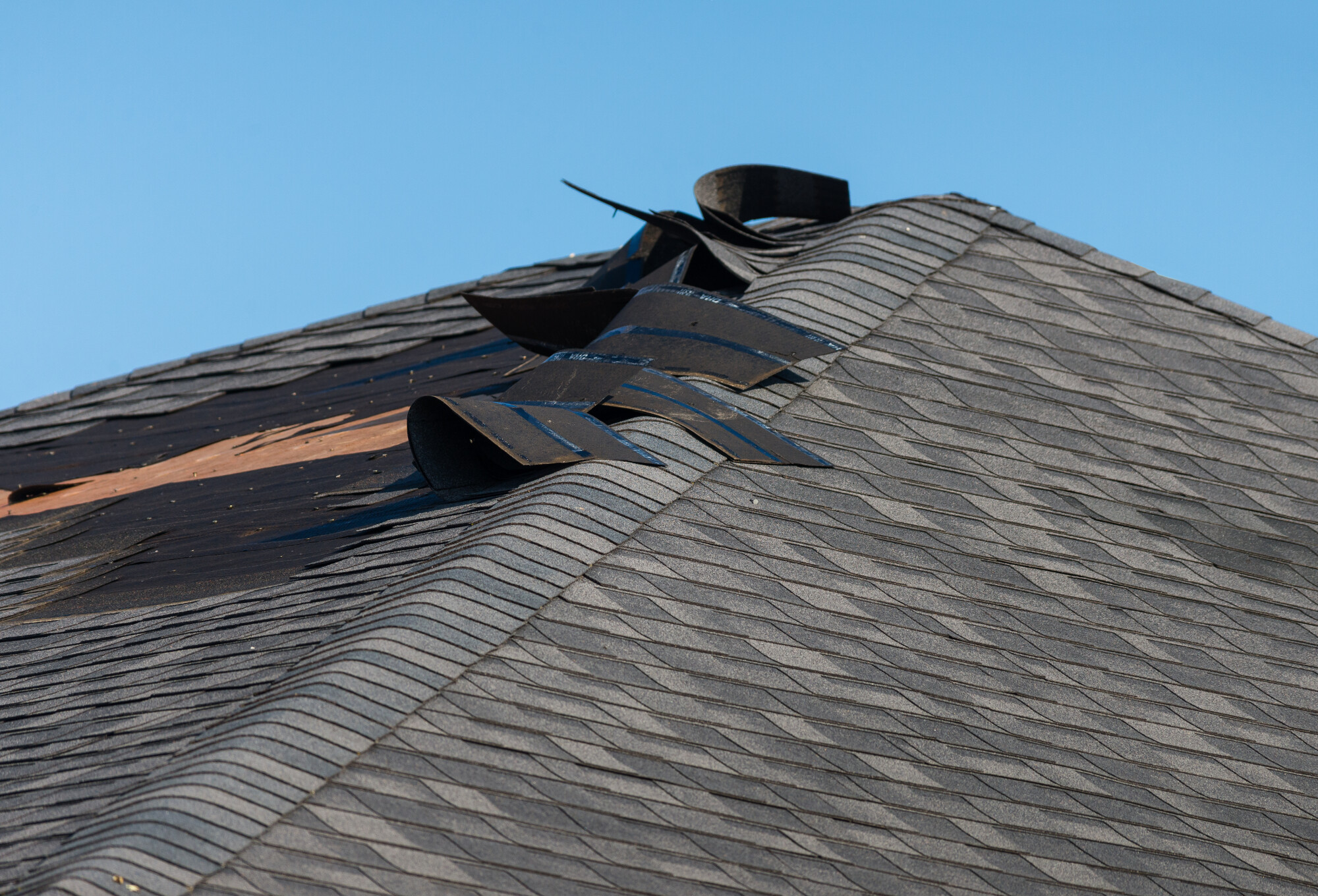 A wind and rain storm has damaged this home's roof.